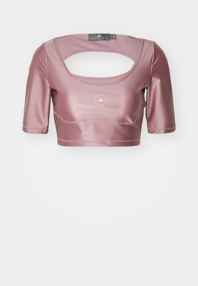 Korte ermene cropped topp i støvrosa sateng med dyp utringing, åpen rygg og gulllogo i midten. Glatt tekstur.