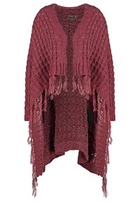 Poncho en tricot bordeaux, avec une large maille ouverte, des bords à franges longs et une coupe décontractée. Un large bandeau côtelé au niveau du cou rehausse le design.