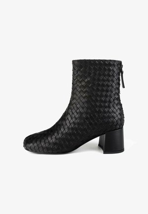 Bottine en cuir tissé noir avec un nez carré et un talon carré robuste. Dotée d'une fermeture éclair et d'une surface texturée.