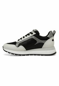 Scarpa sportiva nera e grigia con tomaia in rete e pelle, suola intermedia bianca, suola in gomma nera piatta e accenti grigi a contrasto.