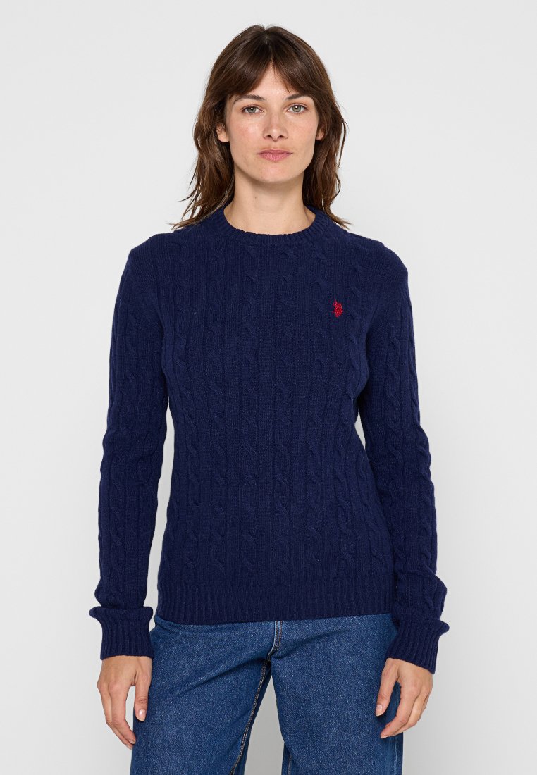 Marineblaue, kabelgestrickte Pullover mit langen Ärmeln, gerippten Bündchen und Rundhalsausschnitt. Mit einem kleinen roten Logo auf der linken Brust.