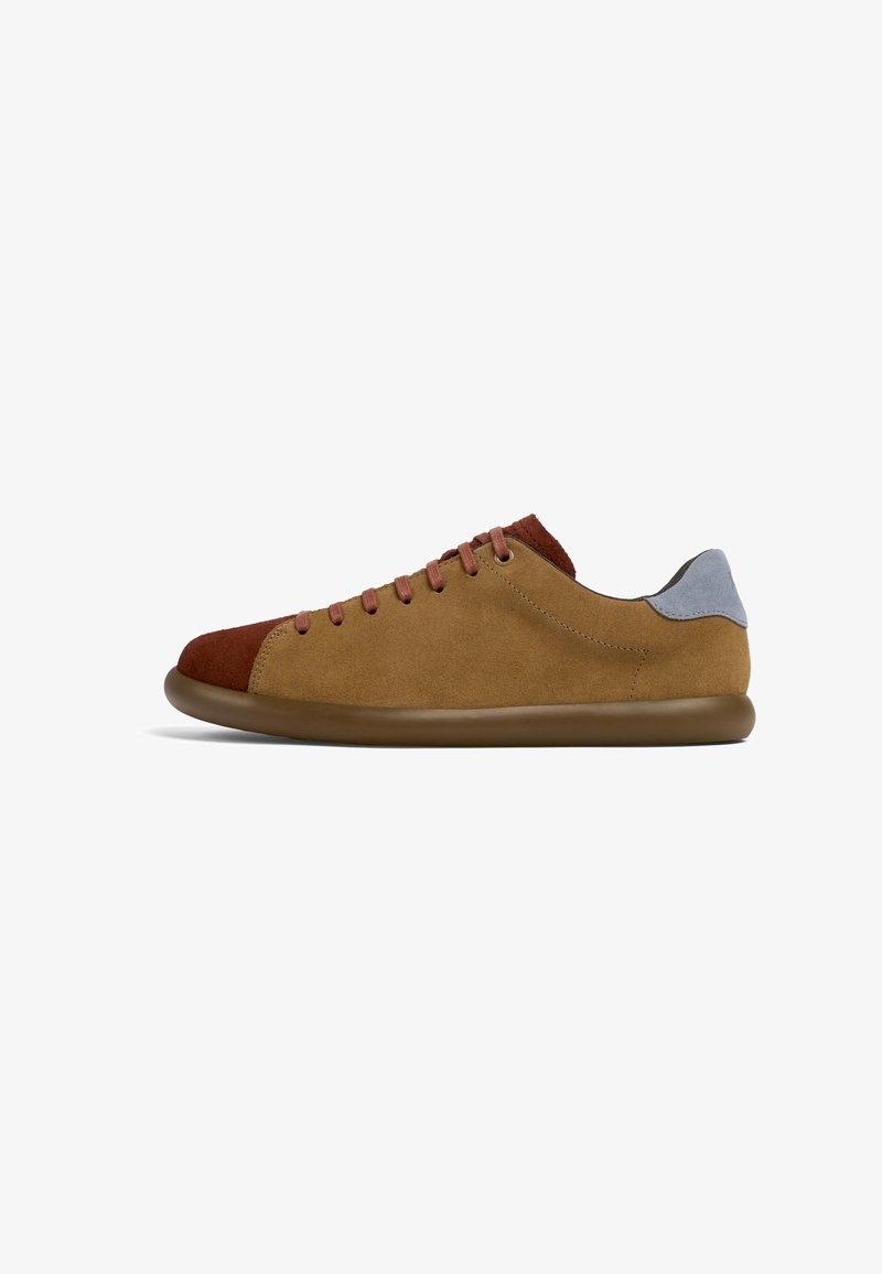 Suede sneakers with a brown and tan color scheme, featuring a red front cap, beige sides, and a blue rear accent. Flat sole and lace-up design.