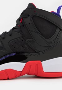 Baskets montantes noires et rouges avec des accents violets, des lacets noirs, des côtés perforés et une semelle intermédiaire blanche sur un fond uni.