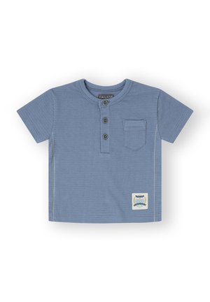 Camisa azul de manga corta con cuello redondo, tres botones, un bolsillo en el pecho, textura de canalé y un parche decorativo en el dobladillo.