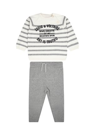 Chemise à rayures grises et blanches à manches longues avec du texte et deux boutons, associée à un pantalon gris avec une ceinture élastique et un détail à nouer.