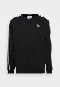 Svart Adidas crewneck sweatshirt med vita trippla ränder på ärmarna och Adidas-logotypen på vänster bröst.