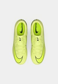 Neon sárga Nike Mercurial focicipők fekete swoosh logókkal, fűzőkkel és textúrázott felső résszel, felülről nézve.