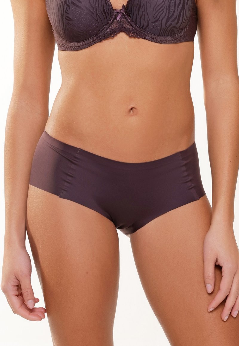 Mutande hipster in tessuto elasticizzato viola con bordi senza cuciture e una consistenza liscia. Caratterizzate da un taglio contemporaneo e da un design minimalista.