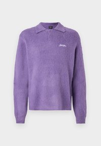 Pulover polo mov, pufos, cu guler, mâneci lungi și trei butoane. Prezintă un logo alb pe piept. Textură moale.