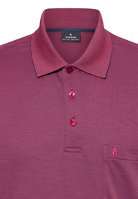 Bordeauxrotes Poloshirt mit einem strukturierten Kragen, einer dreiknöpfigen Knopfleiste und einer Brusttasche mit einem Emblem. Hergestellt aus weichem Strickstoff.