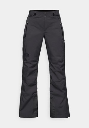 Pantalones de esquí negros con un corte recto, hechos de un tejido duradero, que cuentan con dos bolsillos laterales con cremallera y el logo de The North Face en la pierna izquierda.