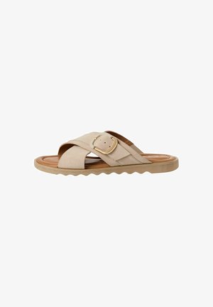 Sandale slide din suede bej cu un design lat încrucișat, accent cu cataramă aurie și talpă din cauciuc texturat, cu o margine ondulată.