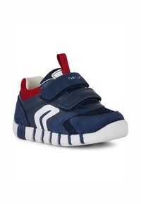 Scarpa da atletica blu navy con design in rete, due cinturini in velcro, dettagli rossi e suola in gomma bianca con scanalature per una migliore aderenza.
