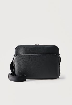 Borsa a tracolla in pelle nera testurizzata con due scomparti con cerniera e tracolla regolabile su sfondo chiaro semplice.