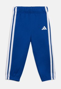 Γαλάζιο αθλητικό παντελόνι από μαλακό ύφασμα, με λευκές ρίγες κατά μήκος των πλευρών και λογότυπο Adidas στο αριστερό μηρό. Ελαστική ζώνη μέσης.