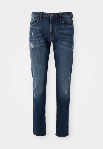 Jeans de mezclilla azul oscuro con corte ajustado, ligero desgaste en los muslos y las rodillas, diseño clásico de cinco bolsillos y cierre de botón.