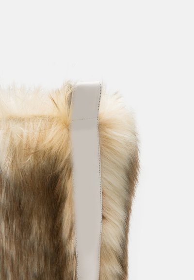 Bolsa de pêlo sintético com um degradê em bege claro e castanho, apresentando uma alça de couro branco suave. Superfície texturizada com pêlo longo e macio.