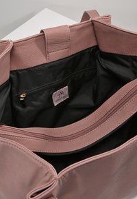 Borsa tote in finta pelle rosa con tasca interna con zip e texture liscia, con fodera nera e etichetta/logo all'interno.