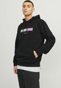 Zwarte hoodie van zachte stof, met een voorvak, een trekkoordkap en een multikleurige logografie op de borst.