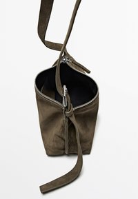 Borsa in suede verde oliva con chiusura a zip, forma ovale e tracolla regolabile. Presenta una texture morbida e una fodera interna nera.
