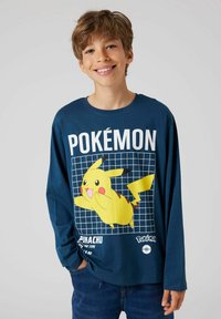 Long-sleeve navy t-shirt featuring Pikachu graphic, grid pattern, and the text "POKÉMON" in white. Soft fabric with a relaxed fit.