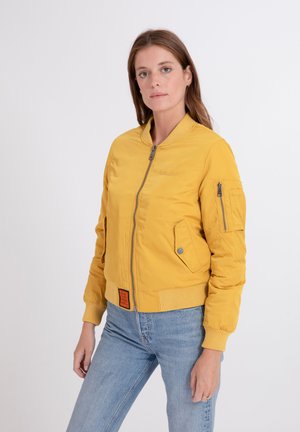 Gelbe Bomberjacke mit einem gerippten Kragen und Bündchen, einem Frontreißverschluss, Seitentaschen und einer Ärmeltasche. Verfügt über ein oranges Etikett am Saum.