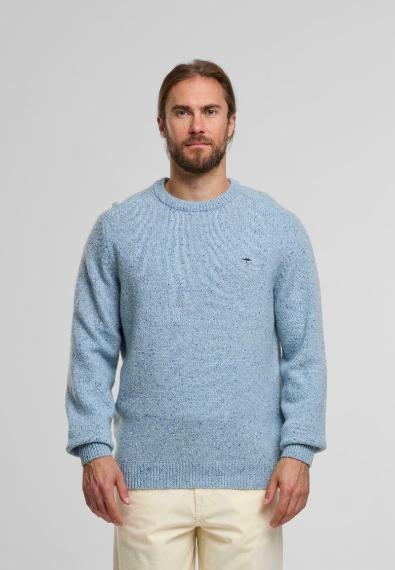 Pull en tricot bleu clair avec un col rond et des poignets côtelés. Présente une texture mouchetée et un logo brodé sur la poitrine.