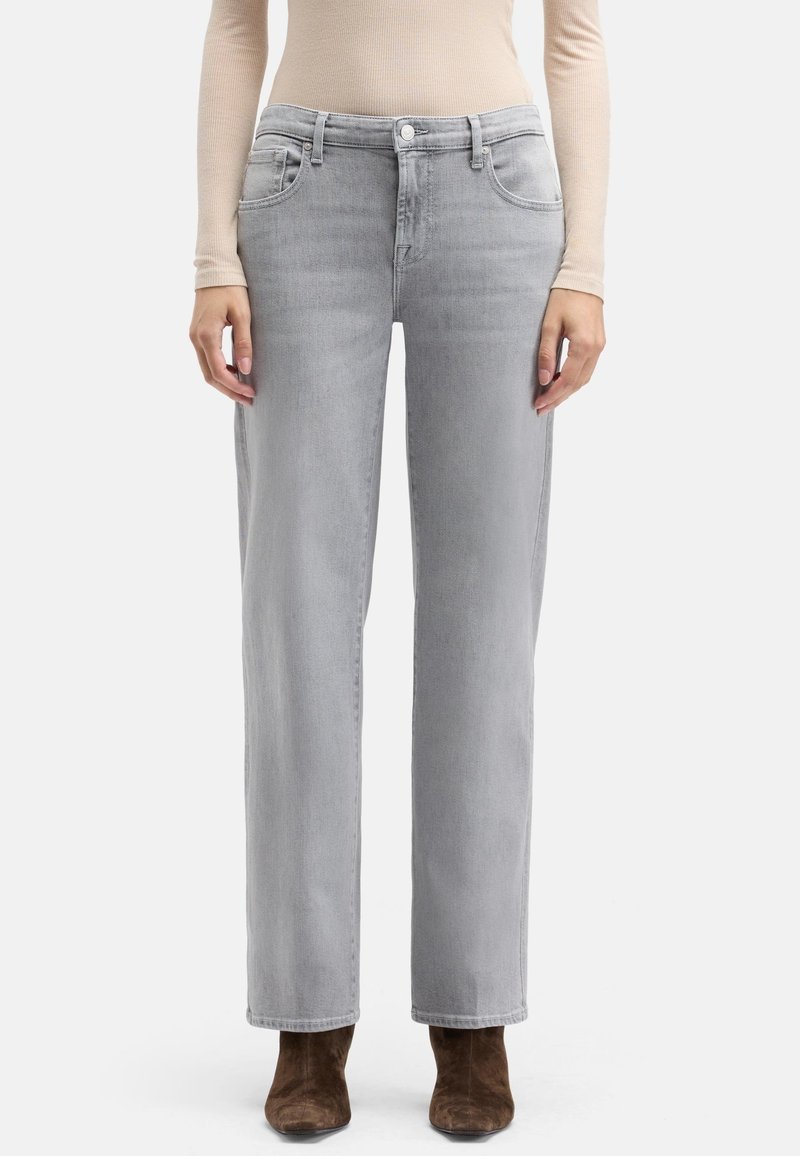 Jasnoszare jeansy o prostych nogawkach z przednimi kieszeniami, delikatnym przetarciem i zapięciem na guzik. Połączone z brązowymi botkami za kostkę.