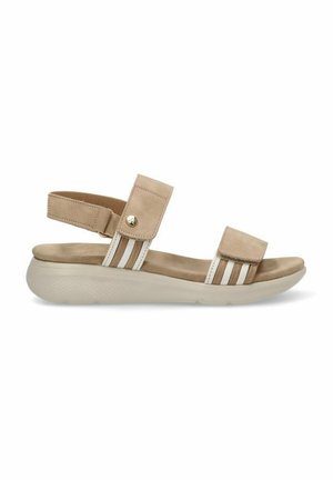 Sandal beige con dos correas ajustables, un ligero acolchado y una suela blanca texturizada con suaves estrías. Acentuada con un pequeño detalle metálico.