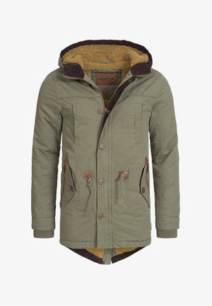 Tummanvihreä parka-takki, jossa on ruskea corduroy-huppu, fleece-vuori, etupainikkeet ja kaksi sivutaskua, joissa on vaaleanruskeita yksityiskohtia.
