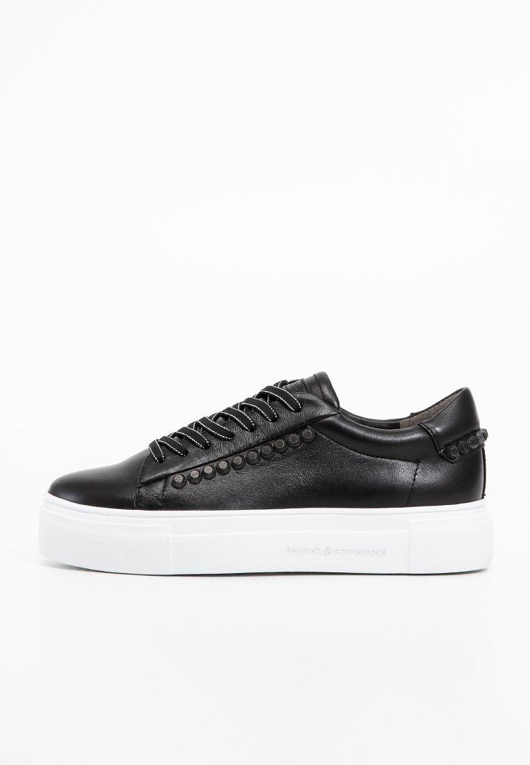Schwarze Ledersneakers zeichnen sich durch ein elegantes Design, runde Zehen und dekorative Nieten an der Seite aus. Dicke weiße Plateausohle.