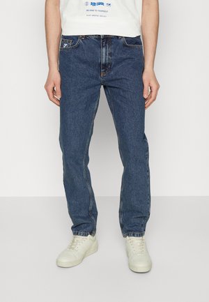 Blå denimjeans med rak passform, med klassisk femficksdesign, subtil söm och en lätt blekning. Matchas med vita sneakers.