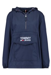 Námorně modrá mikina s kapucí, která má přední kapsu, centrální zip a bílou nášivku s logem "TOMMY JEANS" na hrudi. Hladká tkanina.