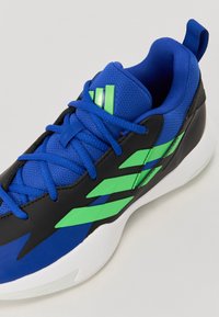 Blue and black athletic shoe with green accents, mesh upper, round toe, and a textured sole. Features striped design and lace-up closure.