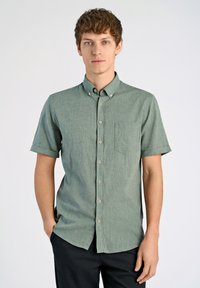 Camisa de botones de manga corta en tejido verde texturizado, con un bolsillo en el pecho, un cuello abotonado y botones marrón claro.