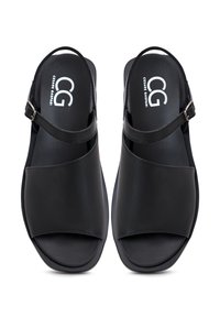 Czarne sandały z gładką skórzaną wykończeniem, z krzyżującym się pasem, regulowanym paskiem wokół kostki i płaską podeszwą.