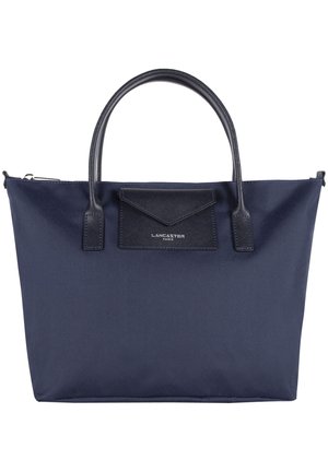 Navy fabric tote bag with dual top handles, a rectangular shape, textured leather accents, and a small pouch detail on the front.