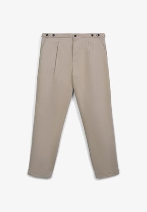Beige Chinos aus glattem Material, mit zwei vorderen Falten, Gürtelschlaufen und zwei schwarzen Knopfverschlüssen am Bund.