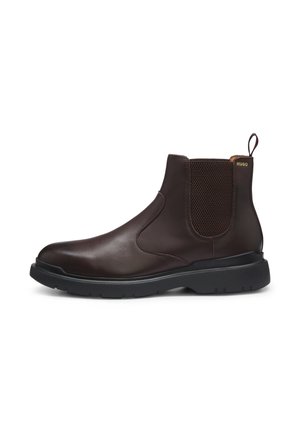 Dunkelbrauner Leder-Chelsea-Boot mit schwarzer Gummisohle und elastischem Seitenpanel, mit Zuglasche und kleinem goldenem "HUGO"-Logo in Knöchelnähe.