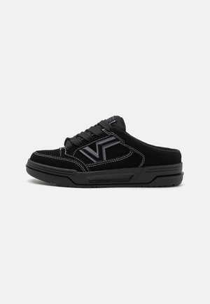 Sapatos de camurça pretos com perfil baixo, apresentando costura branca e um design de logótipo tonificado. Fechamento com atacadores e sola de borracha texturizada.