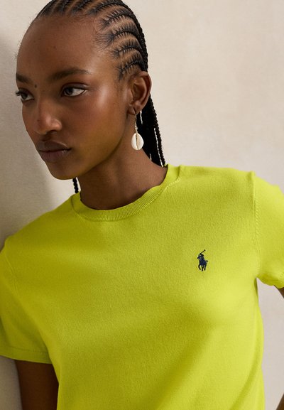 Φωτεινό κίτρινο βαμβακερό μπλουζάκι με στρογγυλή λαιμόκοψη και εφαρμοστή γραμμή. Διαθέτει μικρό ναυτικό λογότυπο στο αριστερό στήθος. Λείο ύφασμα.