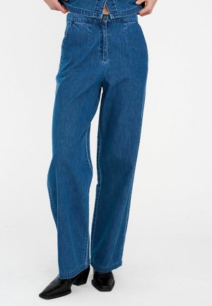 Niebieskie dżinsowe spodnie o szerokich nogawkach, z wysokim stanem, przednimi kieszeniami oraz zamkiem błyskawicznym i guzikiem. Materiał ma gładką fakturę.