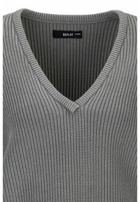 Szary sweter dziany z dekoltem w serek. Charakteryzuje się prążkowaną fakturą i subtelnymi, poziomymi paskami na całej tkaninie. Widoczna metka marki.
