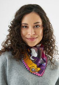 Le foulard en soie présente un design coloré de Snoopy sur un fond violet, avec des accents jaunes, une bordure noire et une texture lisse.