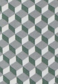 Geometrischer Stoff mit einem sich wiederholenden Muster aus 3D-Würfeln in Grüntönen, Grau und Weiß, mit einer strukturierten Oberfläche.