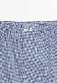 Boxers à carreaux bleus et blancs avec une taille élastique, comportant deux boutons blancs à l'avant et une poche latérale.