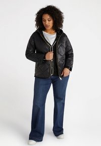 Mustat vuoratut takki hupulla, kultavetoketjulla ja vuorilla. Yhdistetty mustan nappipaidan, sinisten leveälahkeisten farkkujen ja valkoisten tennareiden kanssa.