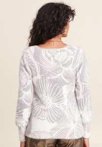 Grau-weißes Blumenmuster-Sweatshirt mit weicher, flauschiger Textur, weitem Halsausschnitt und langen Ärmeln. Es verfügt über einen gerippten Saum und ein detailliertes Blumenmuster.