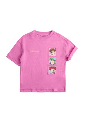 Różowy t-shirt z krótkim rękawem z trzema twarzami postaci z kreskówek i tekstem "The toys are back together" na przedniej prawej stronie.