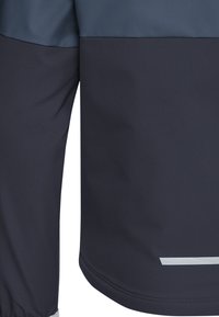 Μανίκι σκούρου μπλε σακακιού και κάτω μέρος πλάτης με γαλάζιο πάνω μέρος γιακά και οριζόντια αντανακλαστική ταινία κοντά στο τελείωμα.